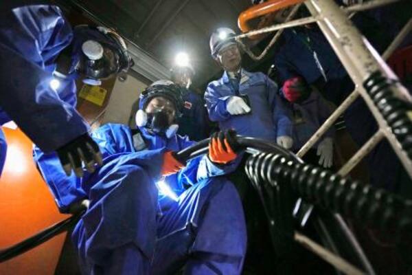 新潟県の柏崎刈羽原発6号機原子炉建屋内で行われた、外部電源を確保する訓練を視察する花角英世知事(右)=14日午前