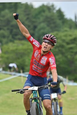 右手を高々と挙げてゴールするブリッツェンの沢田＝富士見パノラマリゾート特設周回コース