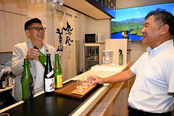 常連客と地酒商品の味わいを紹介する嶋田社長(左)=29日夕、嶋田屋酒店宮みらい店角打ち店舗
