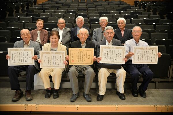 島守忌俳句大会の栃木県知事賞に選ばれた小林さん（前列中央）ら受賞者と選者たち＝23日午後、宇都宮市雀宮町