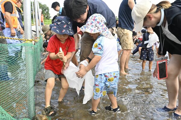 アユのつかみ取りに挑む子どもたち

