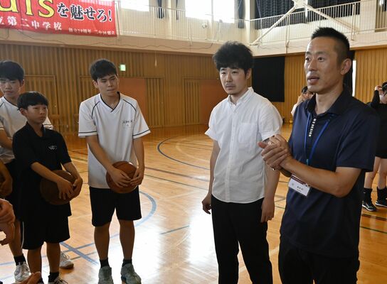 バスケットボール部の生徒を激励する岡田さん（右）