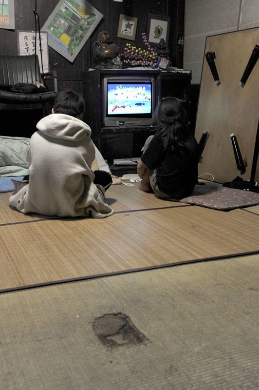 古い農家で暮らす子どもたち。畳には、ろうそくが倒れて焼けた跡が残る=4月下旬、小山市内