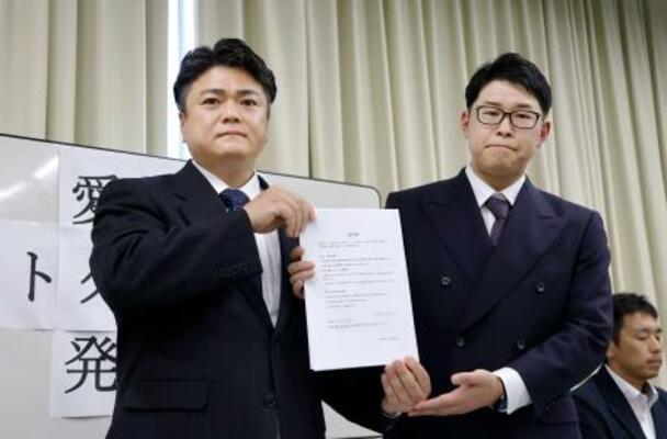 経営者らが署名した誓約書を持つ「愛知県ホストクラブ協議会」の山本洸嗣代表(左)ら=18日午後、名古屋市