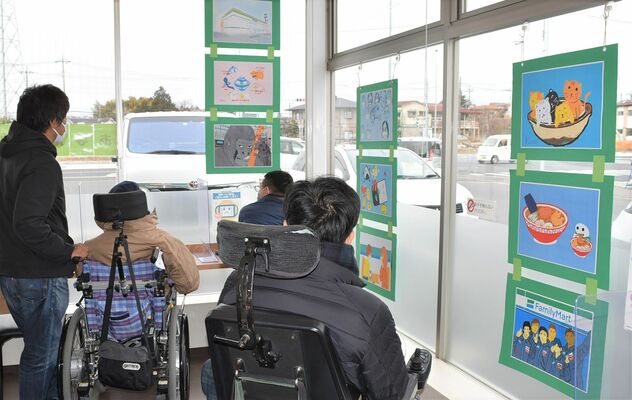 店内に飾られた自らの作品を見る障害者施設の利用者たち