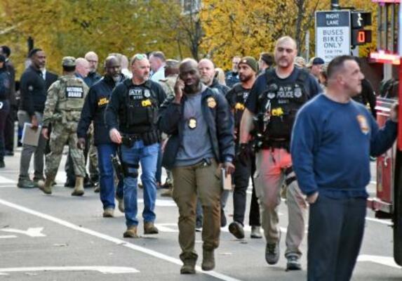 　米ワシントンの銃撃事件現場付近で対応に当たる捜査関係者ら＝２６日（共同）