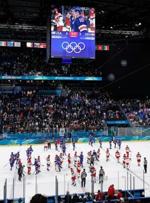 試合を終え、健闘をたたえ合うアイスホッケー男子の米国とデンマークの選手たち=14日、イタリア・ミラノ(共同)