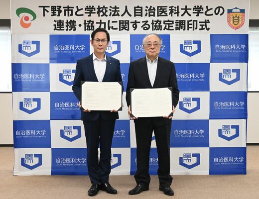 協定書を手にする坂村市長（左）と大石理事長
