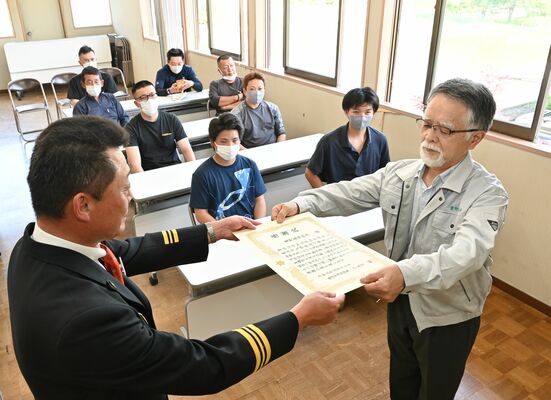 感謝状を受け取る神山組合長（手前右）。奥の８人が消防団員でもある組合員