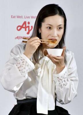記者会見でギョーザのあんかけ丼を試食する荒川静香さん=10日、東京都内