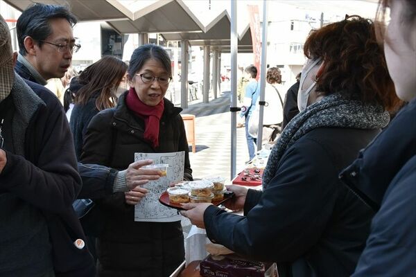 無料配布されたしもつかれを手に取る来場者