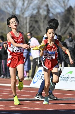 よろしく真岡Ｒの５区石川（左）からアンカー山口にたすきが渡る＝ニッコークリエートスポーツフィールドとちぎ