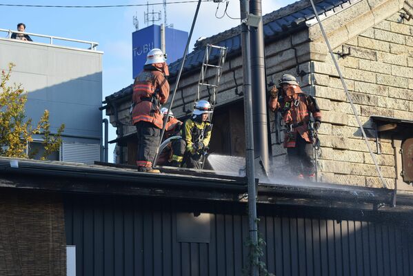 サウナ施設に放水する消防隊員ら＝１２日午後３時２０分、宇都宮市伝馬町