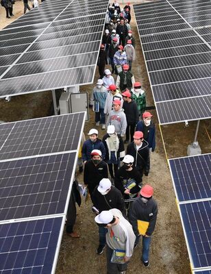 太陽光発電所を見学する児童ら