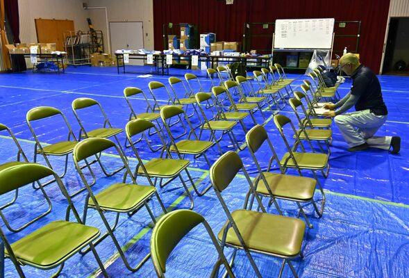 防疫措置を行う職員らが集まる施設の準備を進める関係者＝26日午後８時半、那須塩原市内