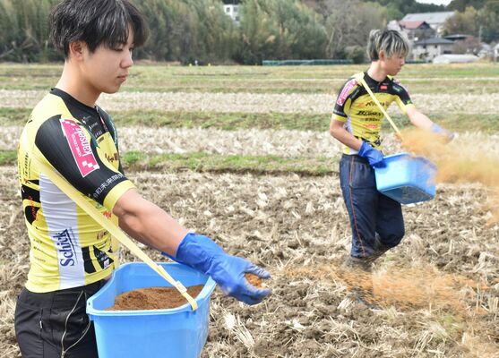 ホテルから提供された堆肥をまく選手たち