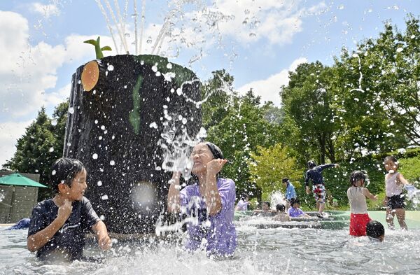 森のせせらぎで水浴びを楽しむ子どもたち＝17日午後０時25分、茂木町のモビリティリゾートもてぎ