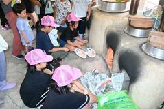 田んぼで稲刈り かまどで炊飯も　