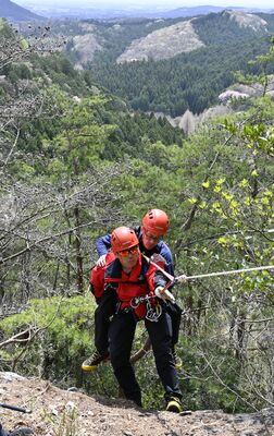 古賀志山での訓練で要救助者役を引き上げる県警山岳警備隊員＝12日午前、宇都宮市内