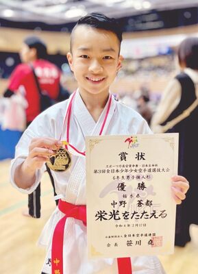 男子個人形６年で優勝し、金メダル、賞状を手に笑顔を見せる中野（一友会伊藤道場）＝函館アリーナ