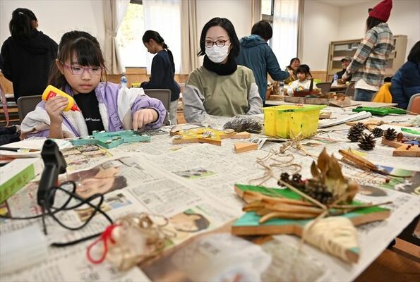 クリスマスリース作りに熱中する親子ら