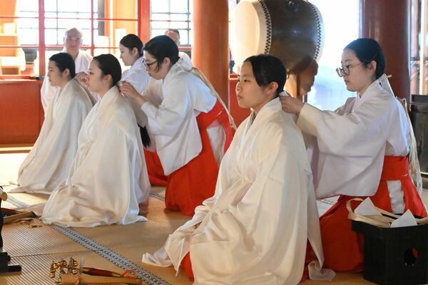 先輩に間政を作ってもらう新人八乙女の３人（手前）