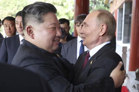 　３日の会談後、抱き合うロシアのプーチン大統領（右）と北朝鮮の金正恩朝鮮労働党総書記＝北京（ゲッティ＝共同）