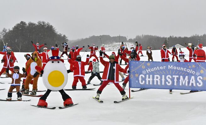 サンタクロース姿などで一斉に滑走する来場客ら＝24日午前、那須塩原市湯本塩原