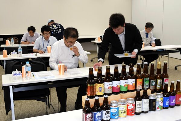 出品されたビールの官能評価を行う審査員＝４日午前、宇都宮市