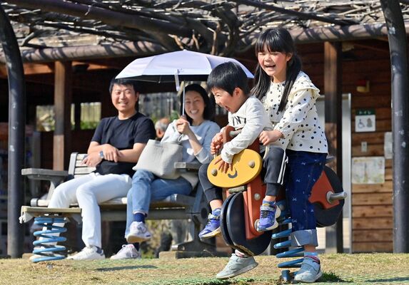 薄着になって遊び、笑顔を見せる親子連れ＝22日午後２時45分、佐野市堀米町