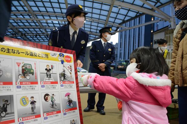 通行人に交通安全を呼びかける警察官ら＝８日午後、宇都宮市江野町