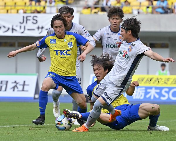 後半38分　相手ゴール前の混戦でボールへ必死に足を伸ばす栃木ＳＣのＭＦ吉野（下）。左はＭＦ杉森＝カンセキスタジアムとちぎ、加藤竜矢撮影