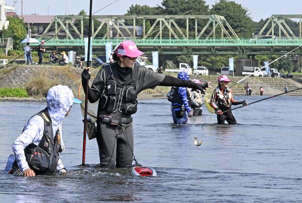 ベテラン釣り師と共にアユ釣りに挑む参加者たち＝24日午前９時20分、大田原市大豆田