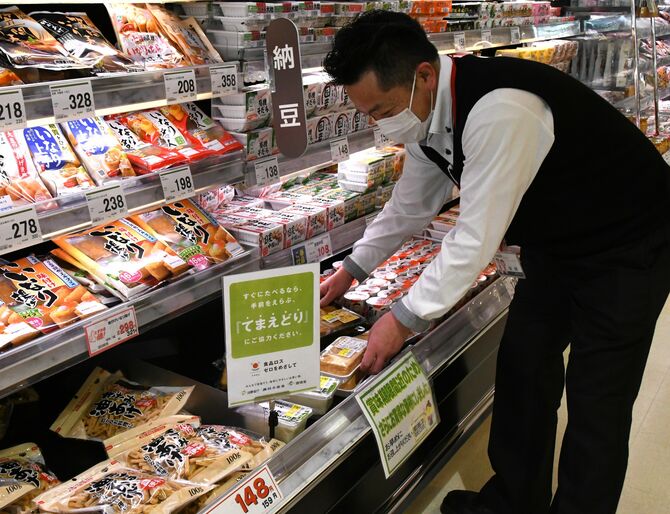 値下げコーナーの商品を整理する田村店長。「てまえどり」も呼びかけている＝５月、宇都宮市
