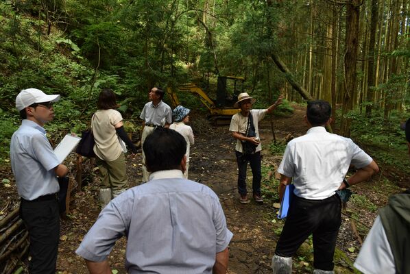 奥佐野農泊推進協議会が整備する里山を視察する参加者＝８日午後、佐野市