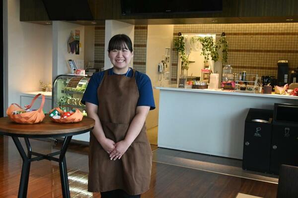 折り紙作品が飾られている店内と高山店長