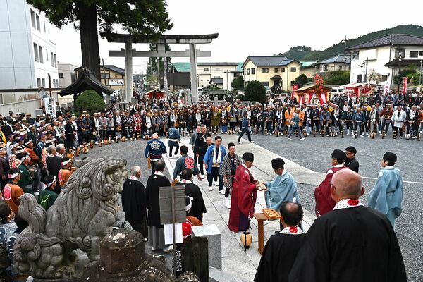 境内で円をつくり順番に番号札を受け取る各町の若衆たち