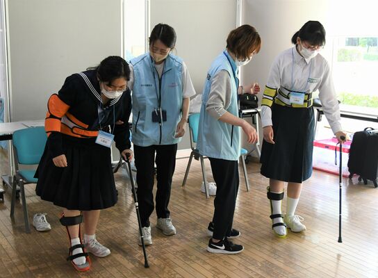 器具を装着し片まひを疑似体験する参加者＝20日午前、宇都宮市