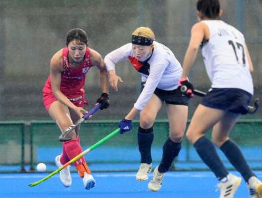 　女子　日本―韓国　第３クオーター、競り合う島田（左）＝川崎重工ホッケースタジアム