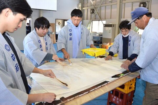 山に烏山和紙を丁寧に貼っていく若衆ら