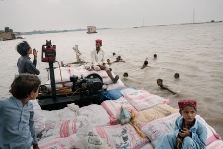 パキスタン南部で水量の増えたインダス川を渡る人々=2024年8月(ゲッティ=共同)
