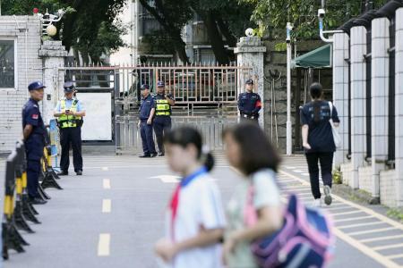 　日本人学校に通う男子児童が登校中に刺殺された事件後、同学校付近を警戒する治安当局者＝２０２４年１０月、中国広東省深セン市（共同）