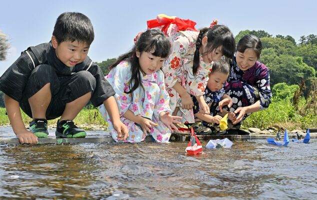 思川に下野人形を乗せた小舟を流す子どもら＝６日午前10時50分、小山市小山、森田大地撮影