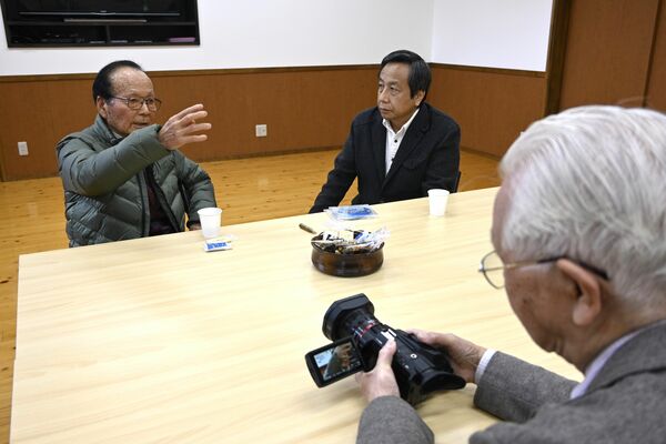 カメラを前に百頭空襲の体験を語る岡村さん（左端）と出演を依頼した堀さん（中央）＝３月上旬、足利市藤本町