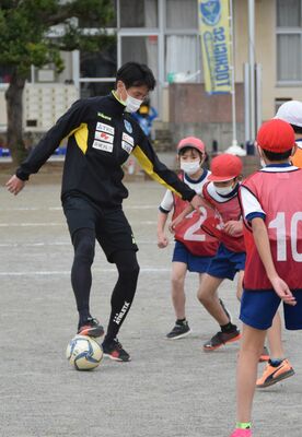 矢野選手（左）とミニゲームに取り組む児童たち