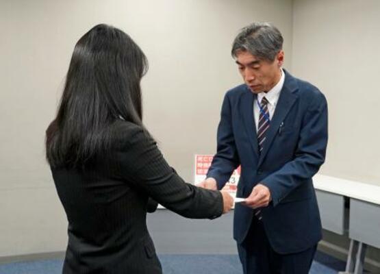 法務省の担当者(右)に嘆願書を手渡す小関孝徳さんの母代里子さん=9日午後、東京都千代田区