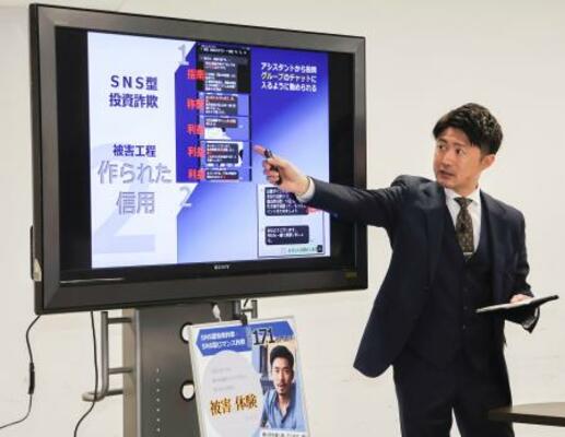 SNS型投資詐欺について説明する警察官=18日午前、愛知県警本部