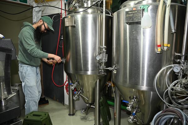 タンクから「見た目も映えるカフェラテビールを取り出す細田さん＝日光市