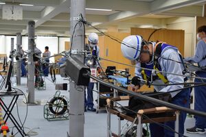 模擬電柱で不具合の確認作業をする競技者＝２６日午前、宇都宮市内