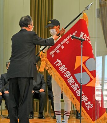 船田学院長から選抜旗を受け取る作新の草野主将